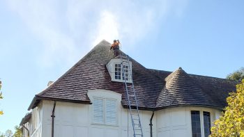 a professional man soft washing a roof in San Francisco